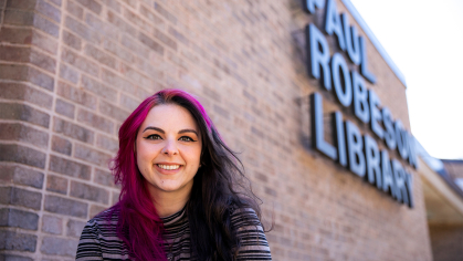 Taryn Cooper sitting in front of the Paul Robeson library