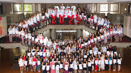 Medical school students holding their white coats 