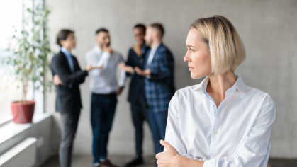 men standing in the background excluding female coworker in the foreground