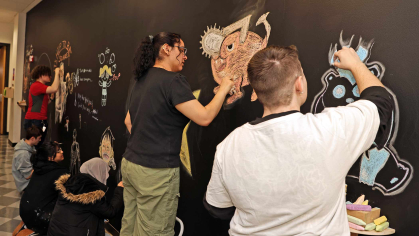 Students (from furthest left to right) Preston Romanienko, Andrew Hargy, Yumna Enver, Aman Kashmiri, Stayshey Sagastume-Castillo and Robin Mager draw on a collaborative chalkboard wall at the Mason Gross School of Arts on Monday.
