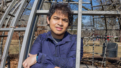 Rutgers student Mukhilan Saravanakumar stands inside playground equipment on Cook Campus.