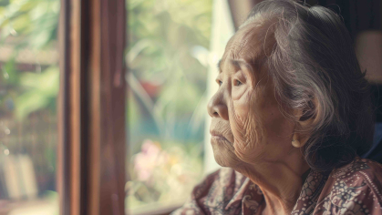 older Chinese adult looking out window