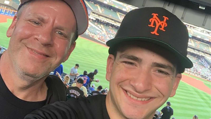 Rutgers-New Brunswick student Tommy Kelson (right) takes a photo with his dad Glenn Kelson during a New York Mets game at Citi Field on Aug. 5, 2022.