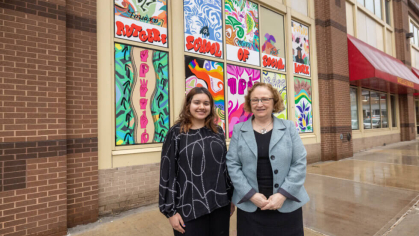 Ria Monga standing next to Rutgers school of social work building