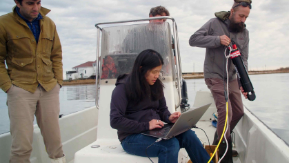 Four scientists conduct an experiment on a research vessel