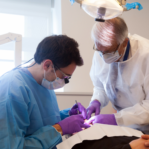 Dental student Roy Kaluzshner (_'13)works with Richard Cassie,DDS assistant clinical professor on a patient