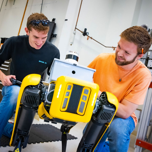Rutgers engineering students working with a walking robot