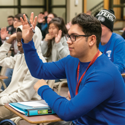 A student raises their hand during a lecture.