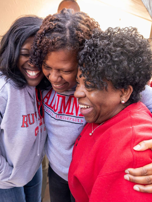 Rutgers alumni embracing in a hug