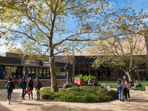 Student by the Walt Whitman statue at Rutgers–Camden