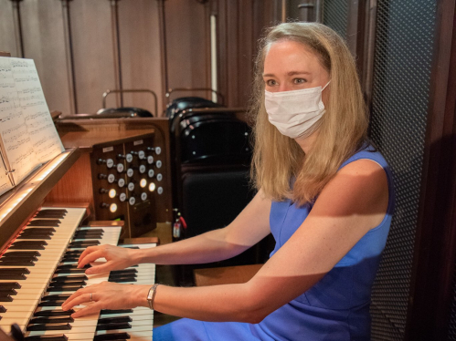 Woman wearing mask playing organ