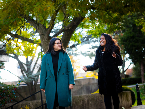 Staff members Maria Zamora and Tasfia Kamal talk while walking on the Newark campus on a bright fall day