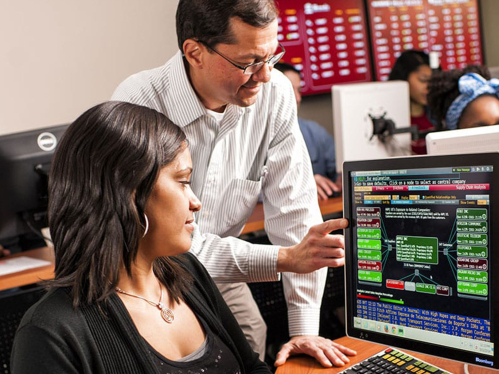 teacher working with a student by the computer