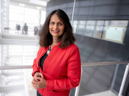 Gita Sharma standing in a hallway of the Rutgers Business School building in Piscataway