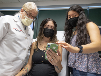 Gloria Bachmann, from left, of the RWJMS Women's Health Institute, expectant mother Michelle Leighton, and student Zoe Reich (SAS ’24) review the Mother's Touch app, a project launched by Reich.