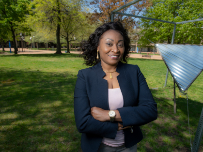 Chinwe Mercy Izegbu standing with her arms folded outside on campus