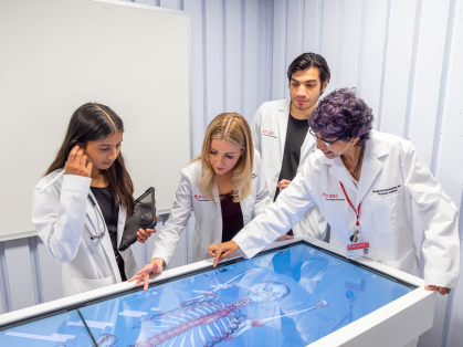 Rutgers SHP students working with a human anatomy model