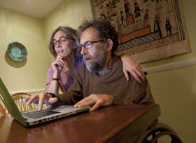 Gabriel looking on his computer with his wife, Janet Heroux