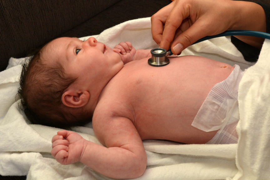 Image of newborn being examined by midwife