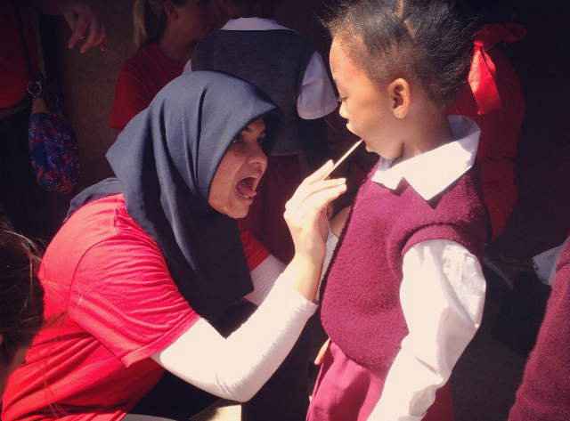 Image of Zainab Poonawalla examining child