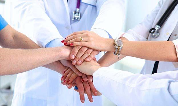 Image of joined hands from a tam of medical professionals
