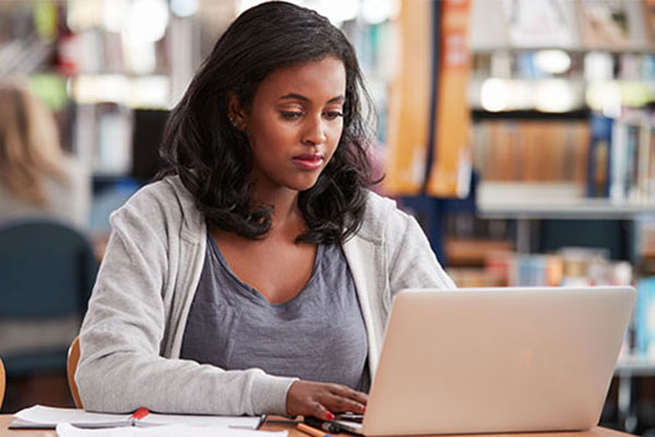 Rutgers Today, Rutgers news - UHere Streamlines Student Enrollment Tally, student uses laptop in library