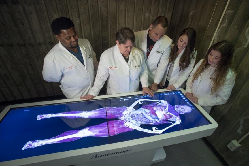 Rebekah J. Thomas, center, an assistant professor at the School of Health Professions, demonstrates how to operate the school’s new virtual dissection table.