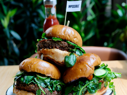 A plate piled with Impossible Burgers on a table.