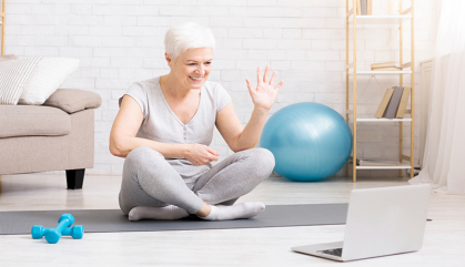 Older adult working out online via laptop