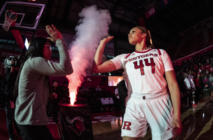 Jordan Wallace high-fiving a fan during a basketball game