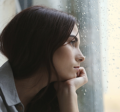 Depressed woman looking out window