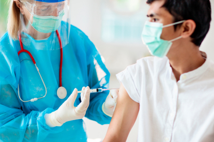 Young man getting vaccinated by female doctor