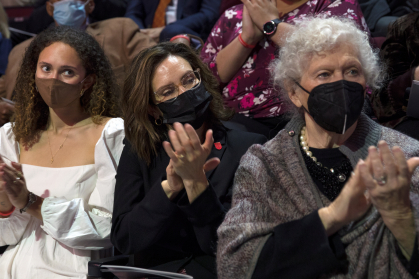 Left to right, the president’s daughter, Emerson Holloway; his wife, Aisling Colón; and his mother-in-law, Patricia Colón, join the audience in applauding Holloway’s remarks.