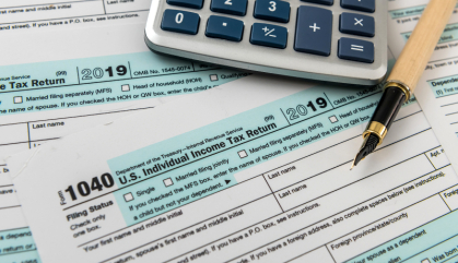 FORM 1040 taxes with calculator and pen