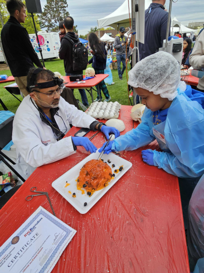 A member of the community doing jello-brain surgery at Rutgers Day