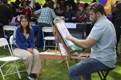 Greysdi Melgar, a student at New Brunswick Health Sciences Technology High School, gets her caricature drawn by Matt Many at Voorhees Mall.