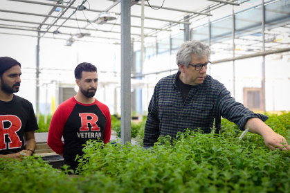 Jim Simon with students in a greenhouse 