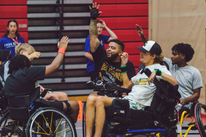 Members of True Grit camp, all of whom are in wheelchairs, cheer after a basketball game (2025)