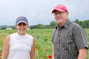 Farmer Christina Couch and Prof. William Hlubik stand in a field.