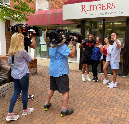 An NBC camera crew shoots footage of the Thai family members Ethan (left), his mother May, his sister Emi and his father Ted.