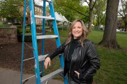Patty Kastner leaning on a ladder outside