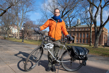 Robert Kopp standing with a bicycle on campus