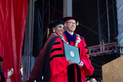 Sheryl Lee Ralph holding her diploma standing with Rutgers President Jonathan Holloway
