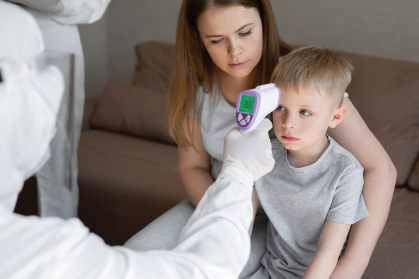 A child has their temperature taken.