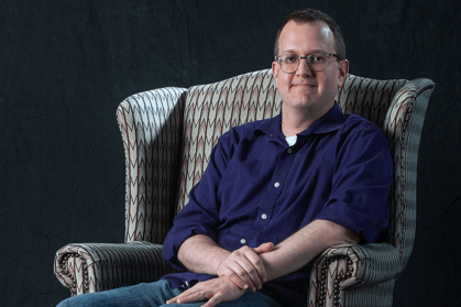 Steven Kemper, associate professor of music technology and composition at Mason Gross School of the Arts. sits in a chair.