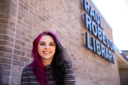 Taryn Cooper sitting in front of the Paul Robeson library