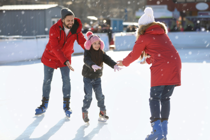 Family ice skating at a rink