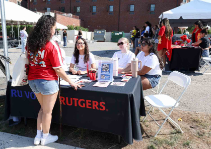 Alejandra Afanador (center, sitting) and other RU Voting Ambassadors operate a registration table outside of the Center for Latino Arts and Culture on Sept. 22.