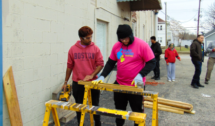 Rakesh Manghani and Izzy Mir cutting wood