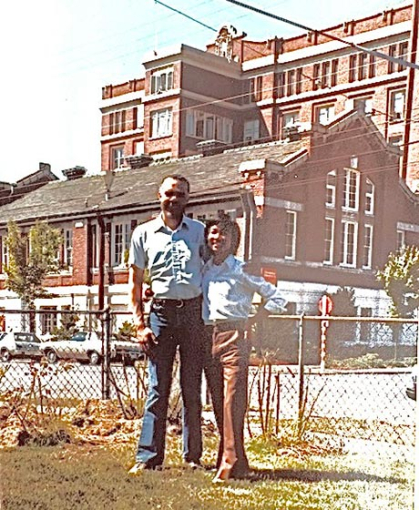 Man and boy stand in front of building